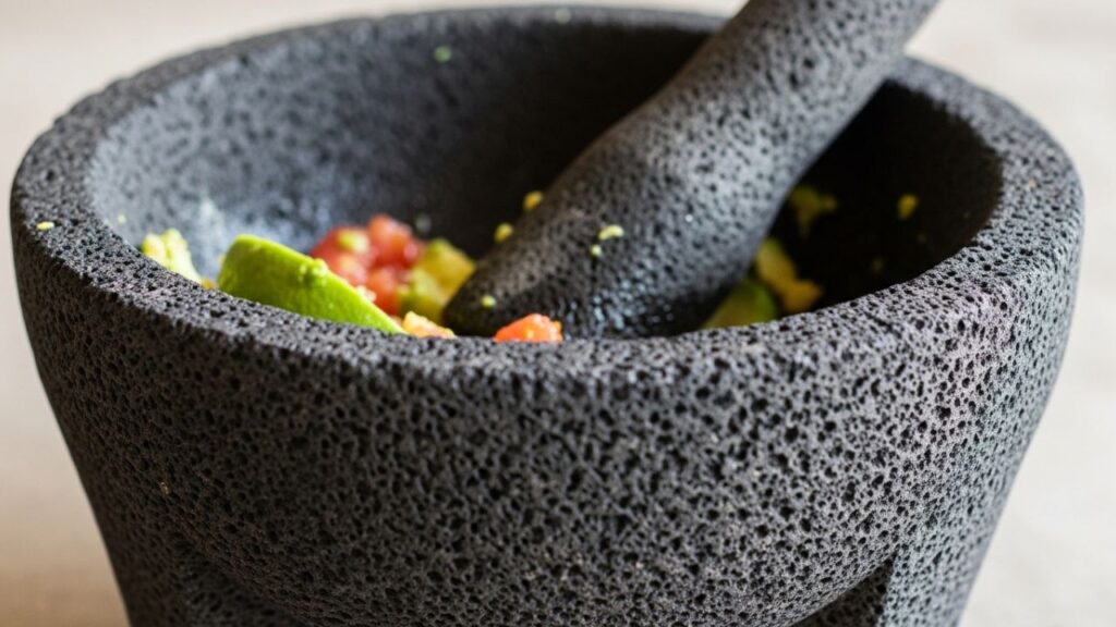 A traditional Mexican basalt molcajete showing the porous volcanic rock texture.